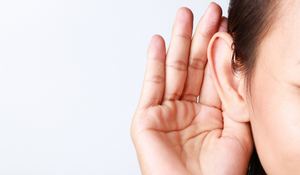 Person using their hand to cup their ear to hear better
